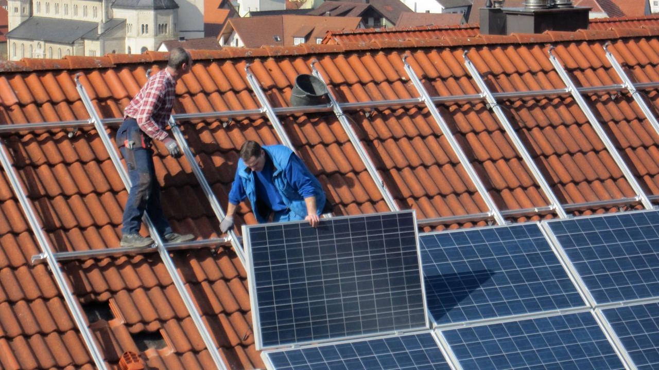 Arbeiter installieren Solarzellen auf einem Dach, aufgenommen am 06.03.2012 in Igersheim. Arbeiter installieren Solarzellen auf einem Dach, aufgenommen am 06.03.2012 in Igersheim.