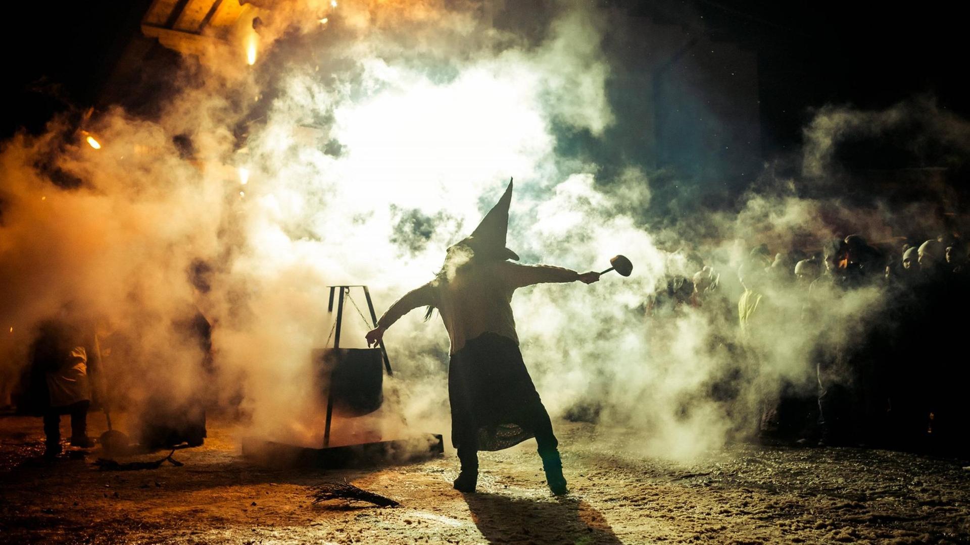 Die Siluette einer Hexe im Rauch. Es ist der "Krampus" der in vielen Alpendörfern brauchgemäß den Winter austreibt. Die Siluette einer Hexe im Rauch. Es ist der "Krampus" der in vielen Alpendörfern brauchgemäß den Winter austreibt.