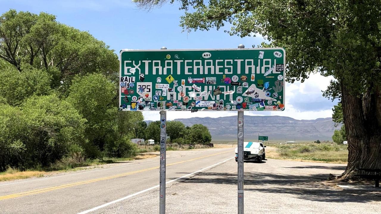 Ein Schild mit der Aufschrift "Extraterrestrial Highway" steht neben einer Straße. Ein Schild mit der Aufschrift "Extraterrestrial Highway" steht neben einer Straße.