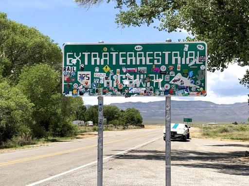 Ein Schild mit der Aufschrift "Extraterrestrial Highway" steht neben einer Straße.