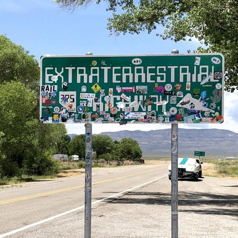 Ein Schild mit der Aufschrift "Extraterrestrial Highway" steht neben einer Straße.