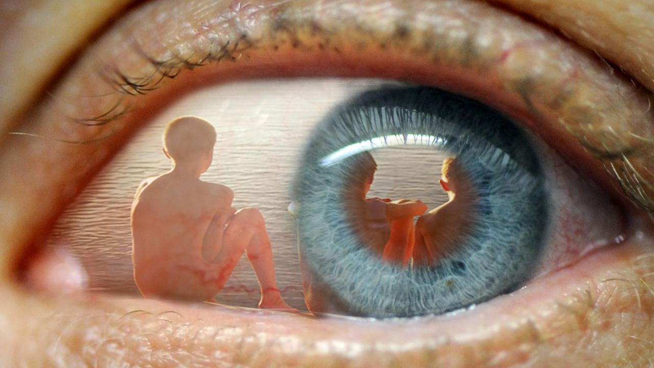 In einem Auge spiegelt sich das Bild von Kindern am Strand. In einem Auge spiegelt sich das Bild von Kindern am Strand.