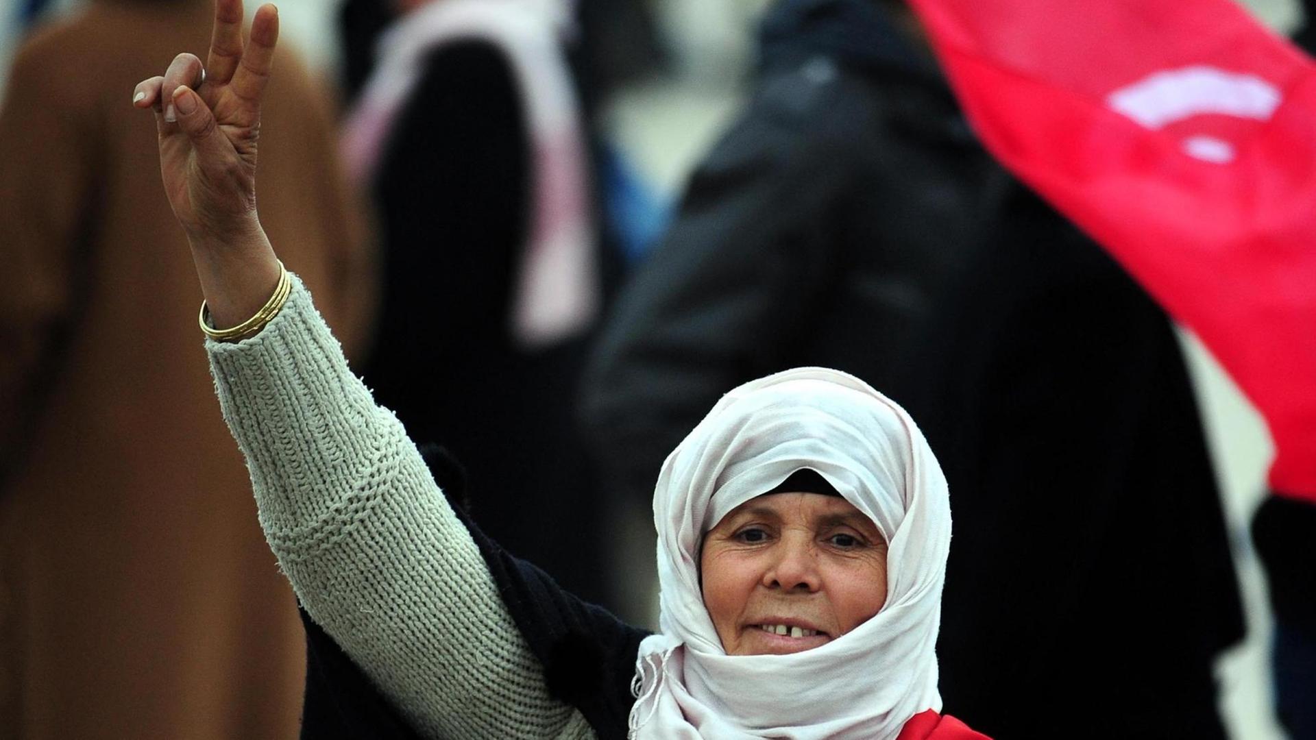 Eine Demonstrantin feiert in Tunesien im Februar 2011 nach dem Rücktritt des damaligen Premierministers Ghannouchi