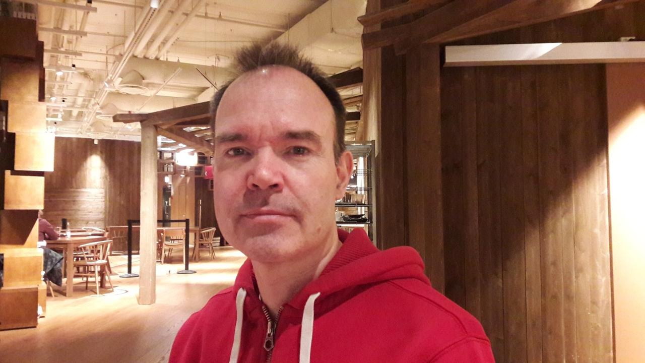 Porträtaufahme Peter Vesterback im roten Kapuzenpulli. Porträtaufahme Peter Vesterback im roten Kapuzenpulli.