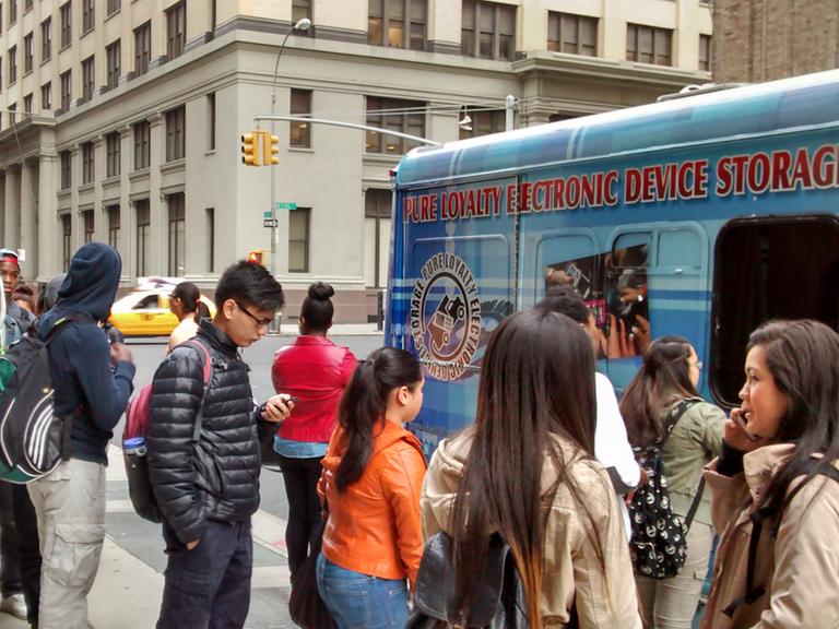 Schüler geben vor einer Schule in New York City ihre Telefone ab.