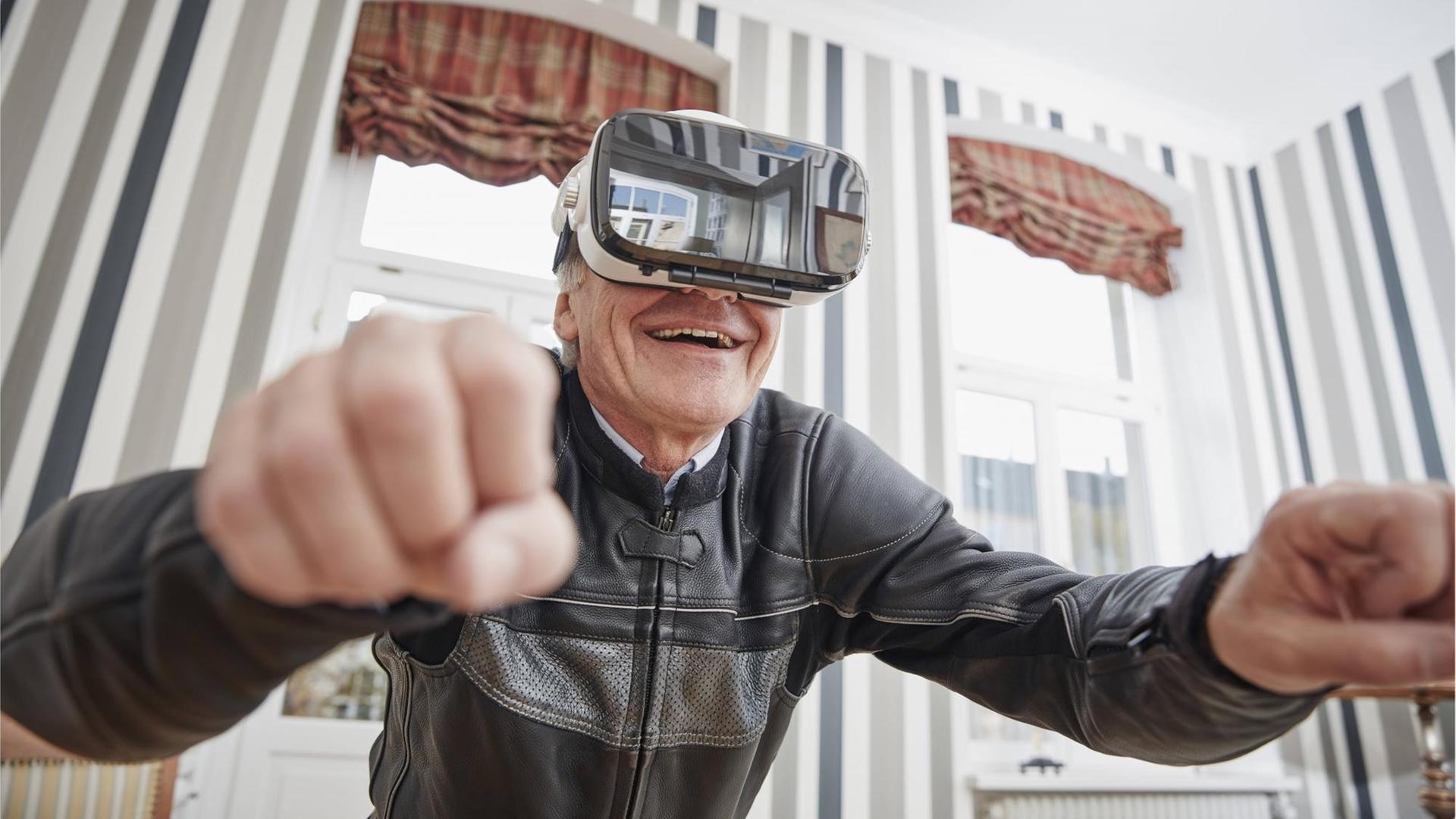 Ein älterer Mann in einer Motorradjacke trägt eine VR-Brille. Ein älterer Mann in einer Motorradjacke trägt eine VR-Brille.
