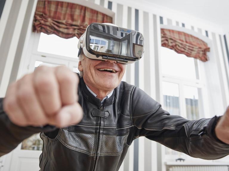 Ein älterer Mann trägt eine VR-Brille.