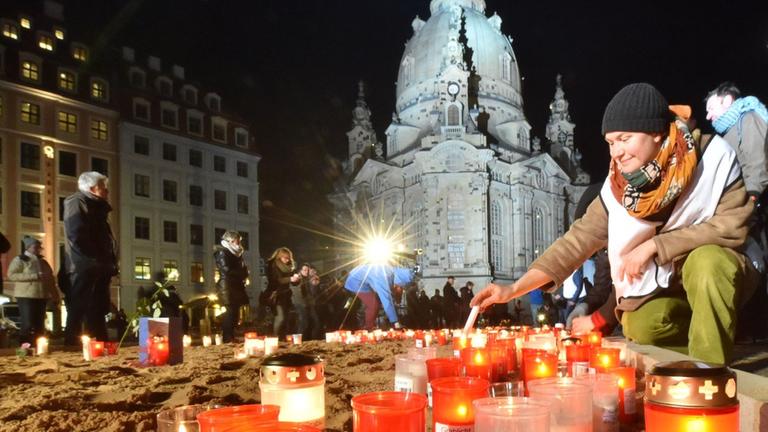 Grablichter und Kerzen brennen während der Gedenkveranstaltung zum 70. Jahrestag der Bombardierung von Dresden. Im Hintergrund die wieder aufgebaute Frauenkirche. Grablichter und Kerzen brennen während der Gedenkveranstaltung zum 70. Jahrestag der Bombardierung von Dresden. Im Hintergrund die wieder aufgebaute Frauenkirche.