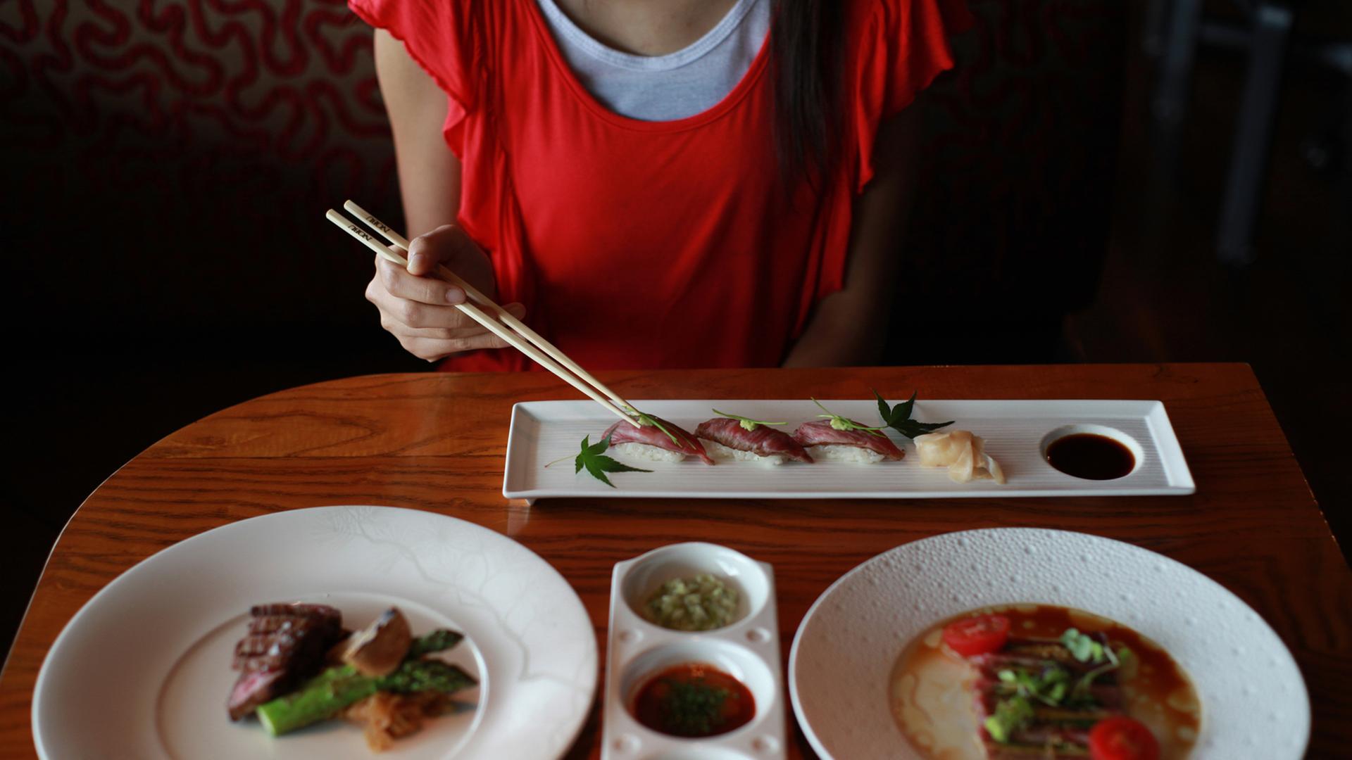 Eine Frau ist in einem Hongkonger Restaurant Sushi. Eine Frau ist in einem Hongkonger Restaurant Sushi.