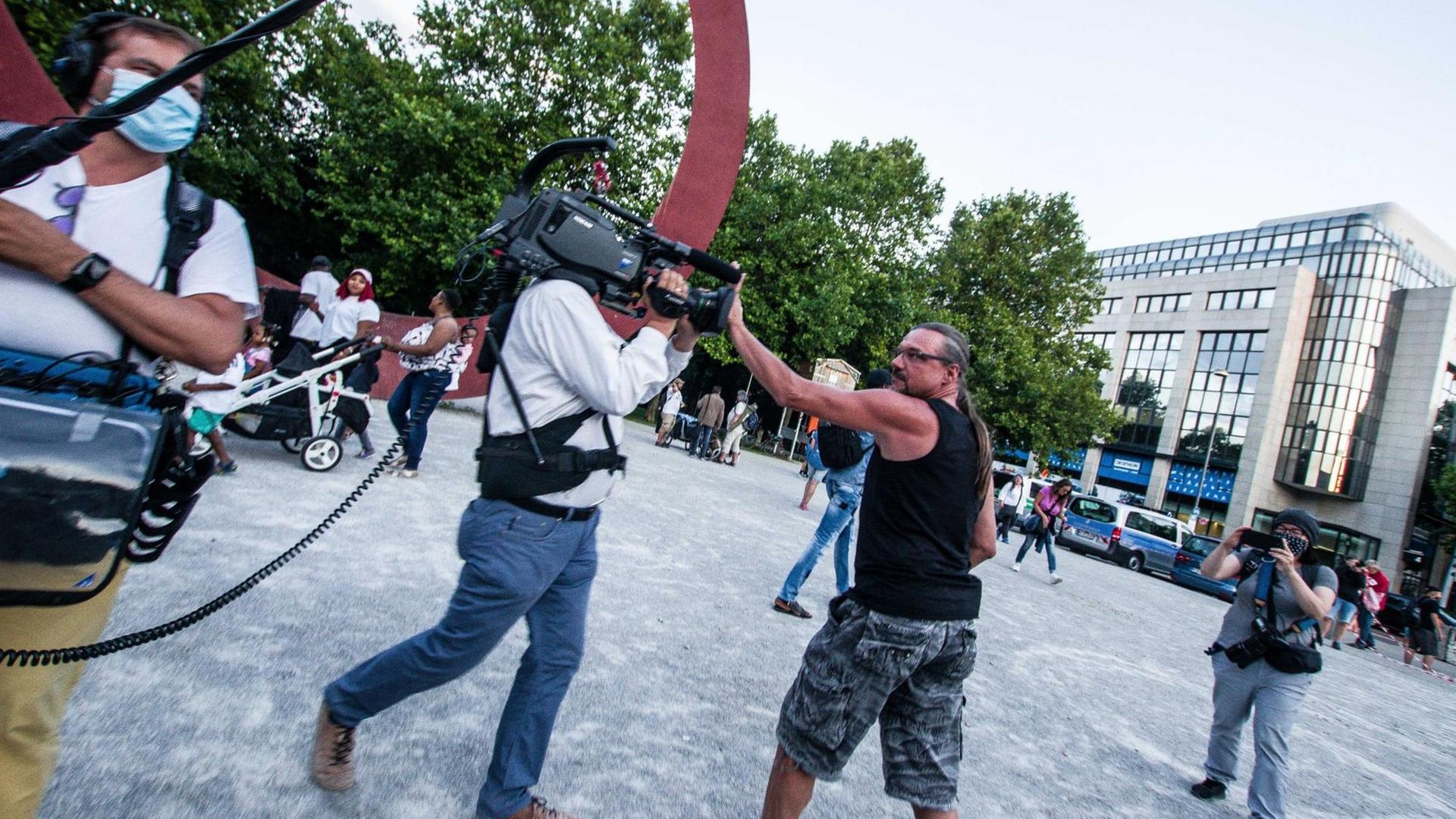 Ein Mann attackiert ein Fernseh-Team bei einer Demonstration gegen die Corona-Regeln.