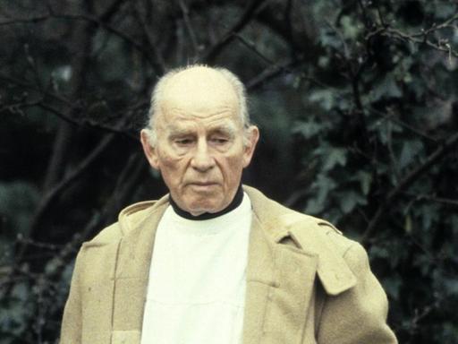 Arno Breker im Juni 1983 im Garten seines Hauses in Düsseldorf-Lohhausen. Die Hände verschwinden in den Manteltaschen, mit einem nachdenklichen, nach unten gerichteten Blick.