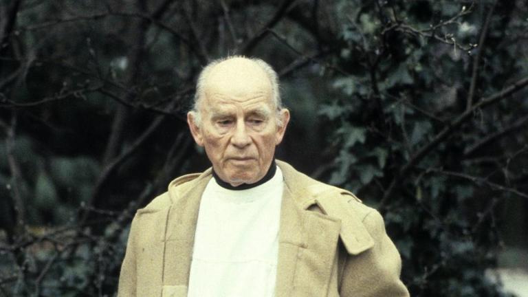 Arno Breker im Juni 1983 im Garten seines Hauses in Düsseldorf-Lohhausen. Die Hände verschwinden in den Manteltaschen, mit einem nachdenklichen, nach unten gerichteten Blick. Arno Breker im Juni 1983 im Garten seines Hauses in Düsseldorf-Lohhausen. Die Hände verschwinden in den Manteltaschen, mit einem nachdenklichen, nach unten gerichteten Blick.