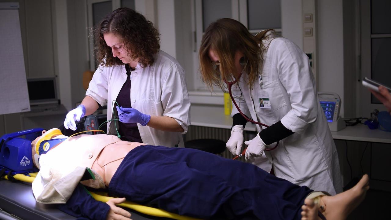 Die Medizinstudenten Marie (l) und Helene führen in der Charité in Berlin bei der Übung "Simulierte Rettungsstelle" eine Notfallbehandlung an einem Dummy durch. Die Medizinstudenten Marie (l) und Helene führen in der Charité in Berlin bei der Übung "Simulierte Rettungsstelle" eine Notfallbehandlung an einem Dummy durch.