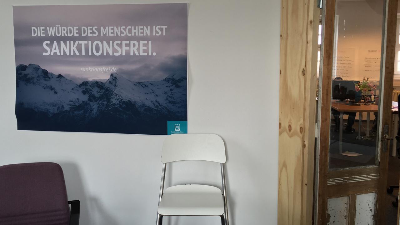 Im Besprechungsraum der Initiative hängt ein Plakat mit der Aufschrift: "Die Würde des Menschen ist sanktionsfrei" Im Besprechungsraum der Initiative hängt ein Plakat mit der Aufschrift: "Die Würde des Menschen ist sanktionsfrei"