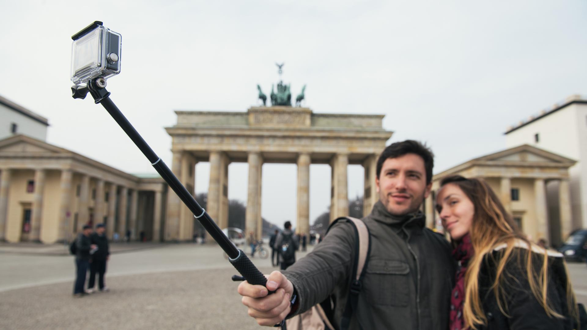 Zwei Touristen machen am Brandenburger Tor in Berlin ein Selbstporträt mit einem "Selfie-Stick" Zwei Touristen machen am Brandenburger Tor in Berlin ein Selbstporträt mit einem "Selfie-Stick"