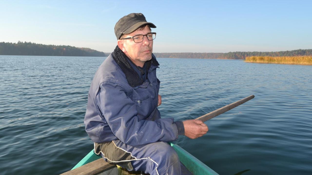 Der Fischer Rainer Böttcher fährt mit einem Boot auf dem Großen Stechlinsee.