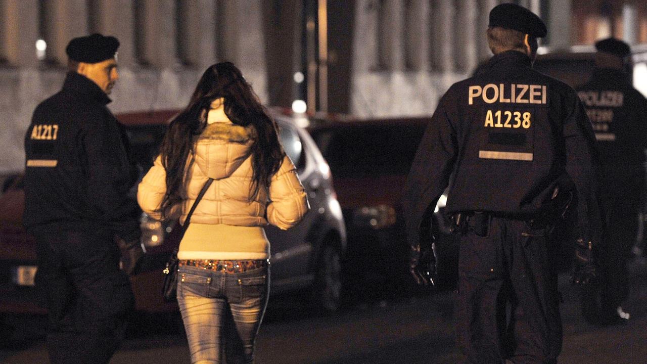 Polizisten begleiten bei einem Polizeieinsatz mit Durchsuchungen am 08.11.2013 in der Kurfürstenstraße in Berlin eine Frau zu einem Kontrollpunkt. Polizisten begleiten bei einem Polizeieinsatz mit Durchsuchungen am 08.11.2013 in der Kurfürstenstraße in Berlin eine Frau zu einem Kontrollpunkt.