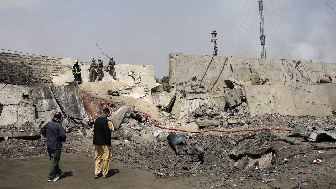 Afghanische Sicherheitsleute stehen am Rand des Kraters einer Explosion Afghanische Sicherheitsleute stehen am Rand des Kraters einer Explosion