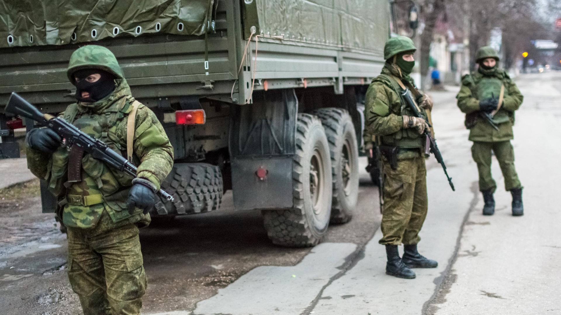 Bewaffnete Männer in Uniform stehen auf einer Straße von Simferopol Bewaffnete Männer in Uniform stehen auf einer Straße von Simferopol