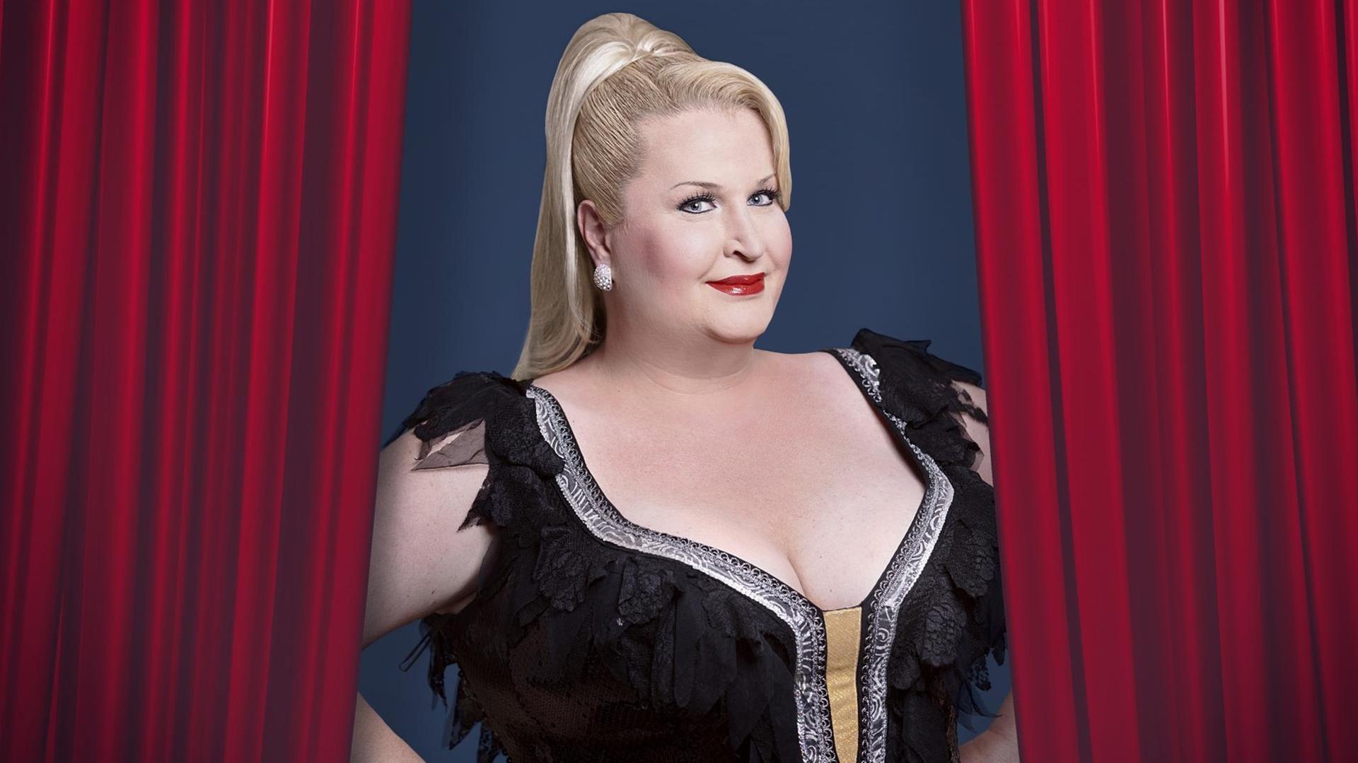 Die Comedienne Daphne de Luxe steht vor einem roten Vorhang Die Comedienne Daphne de Luxe steht vor einem roten Vorhang