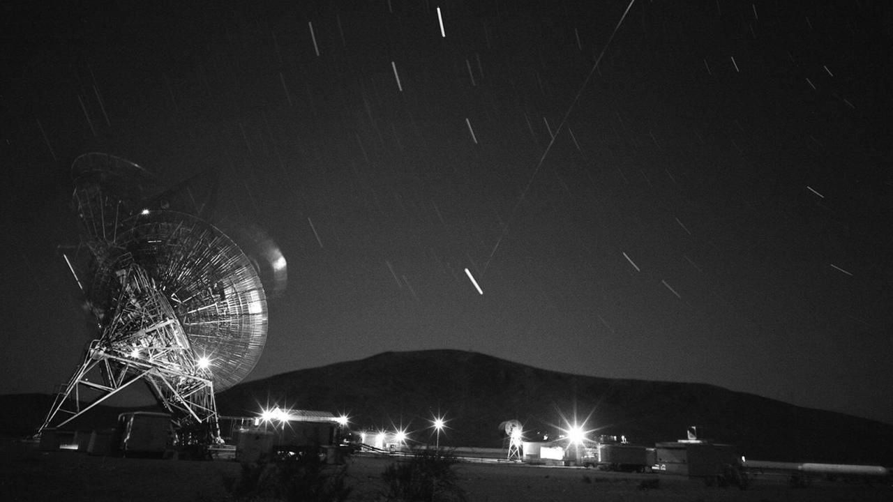 Der erste US-amerikanische Kommunikationssatellit überquert 1960 ein Radio-Teleskop des Goldstone Deep Space Communications Complex in Kalifornien. Der erste US-amerikanische Kommunikationssatellit überquert 1960 ein Radio-Teleskop des Goldstone Deep Space Communications Complex in Kalifornien.
