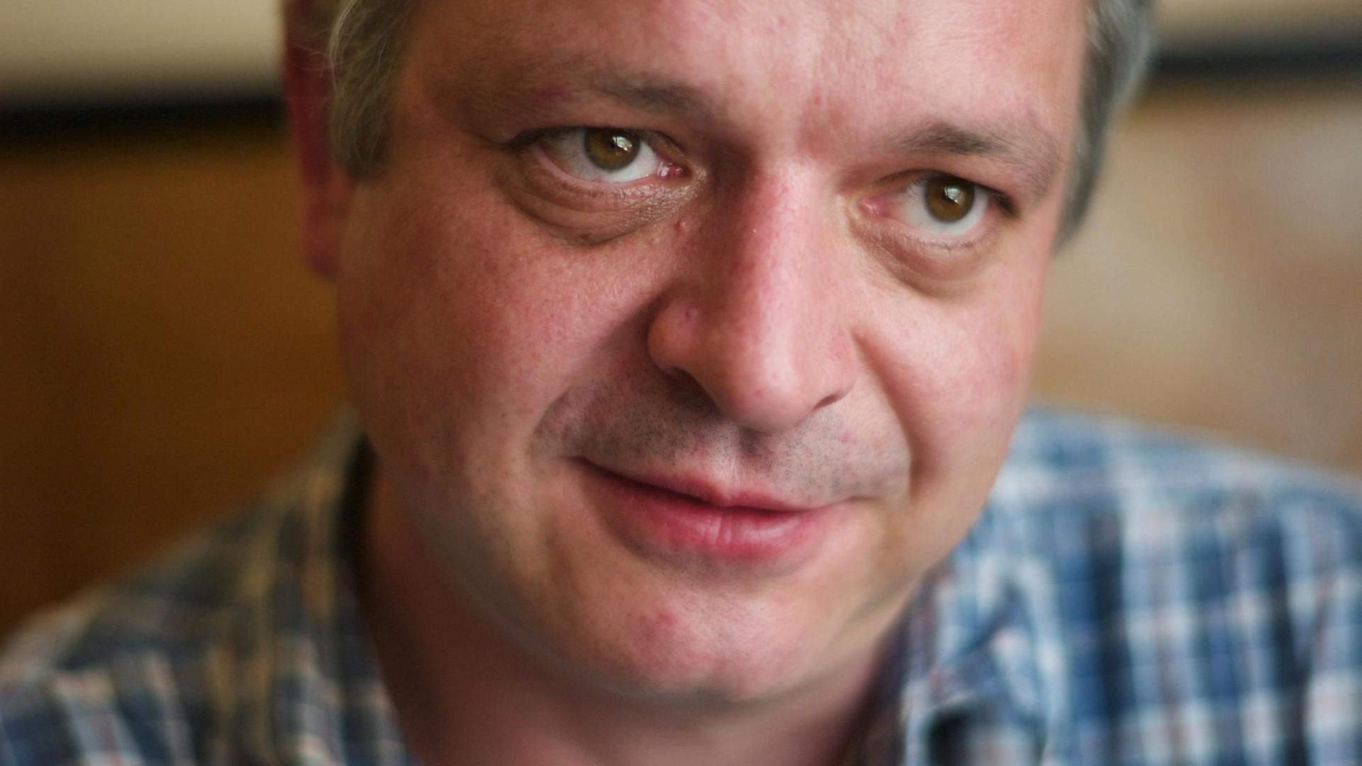 Der Stuttgarter Schriftsteller Ulf Stolterfoht sitz in einem Wiener Café, er trägt ein kariertes Hemd und blickt leicht an der Kamera vorbei. Der Stuttgarter Schriftsteller Ulf Stolterfoht sitz in einem Wiener Café, er trägt ein kariertes Hemd und blickt leicht an der Kamera vorbei.