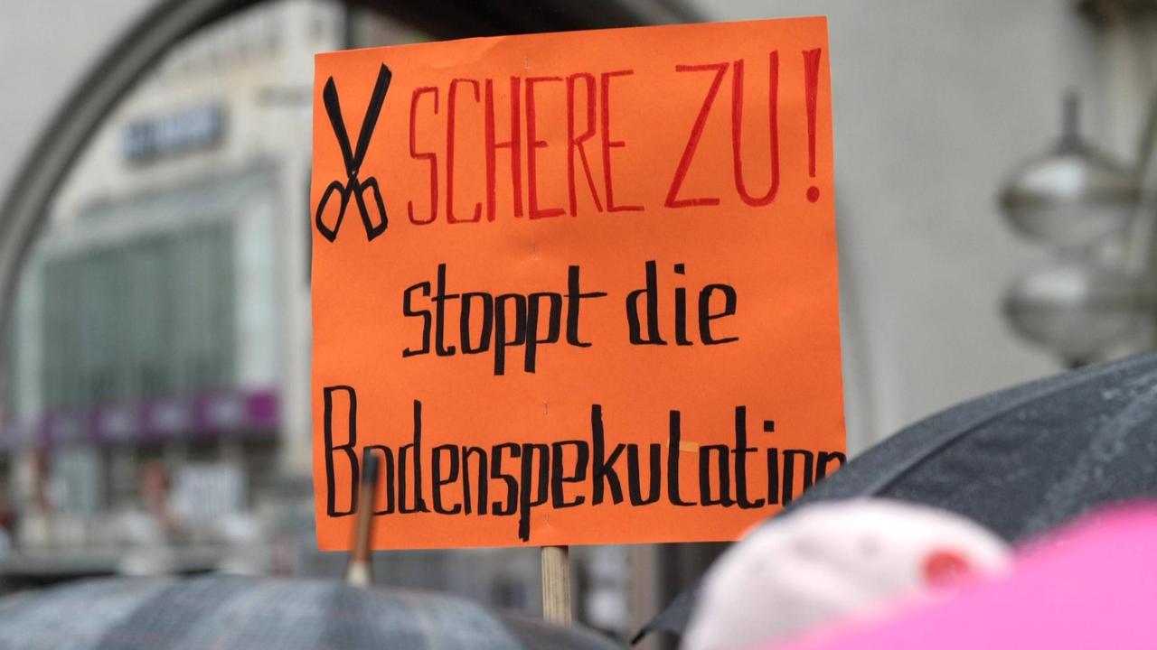 Demonstration und Kundgebung am Karlsplatz Stachus in München anlässlich der Mietpreis Explosion in der Stadt: Plakate und Transparente mit Schriftzug Schere zu. Stoppt die Bodenspekulation. Demonstration und Kundgebung am Karlsplatz Stachus in München anlässlich der Mietpreis Explosion in der Stadt: Plakate und Transparente mit Schriftzug Schere zu. Stoppt die Bodenspekulation.