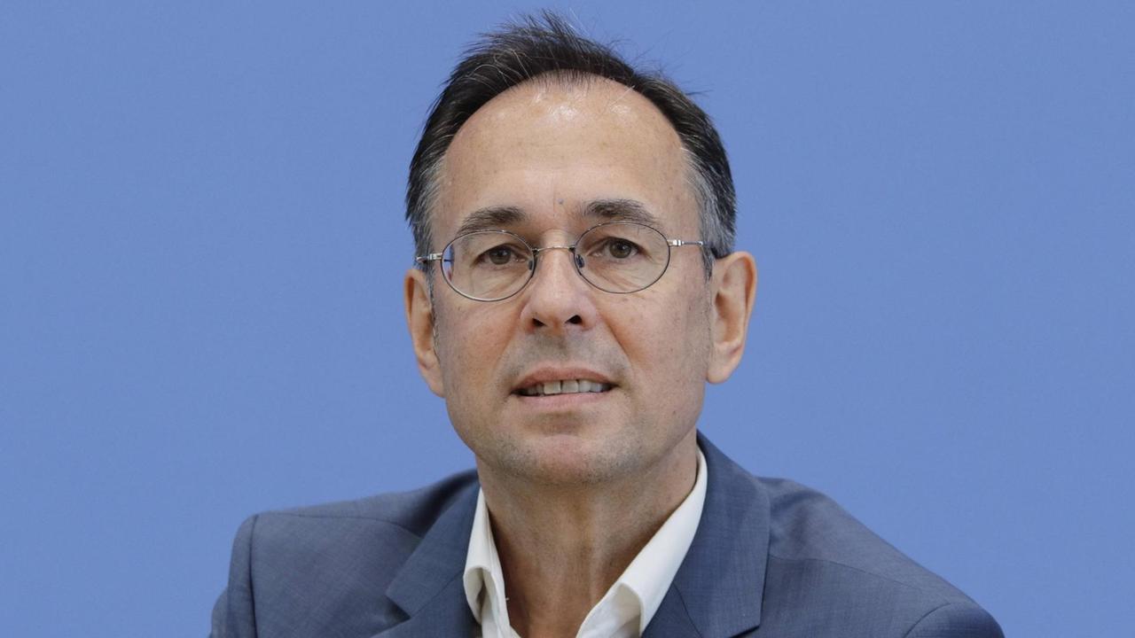 Andreas Zick blickt konzentriert aber freundlich vor einem hellblauen Hintergrund sitzend in Richtung des Betrachters. Andreas Zick blickt konzentriert aber freundlich vor einem hellblauen Hintergrund sitzend in Richtung des Betrachters.