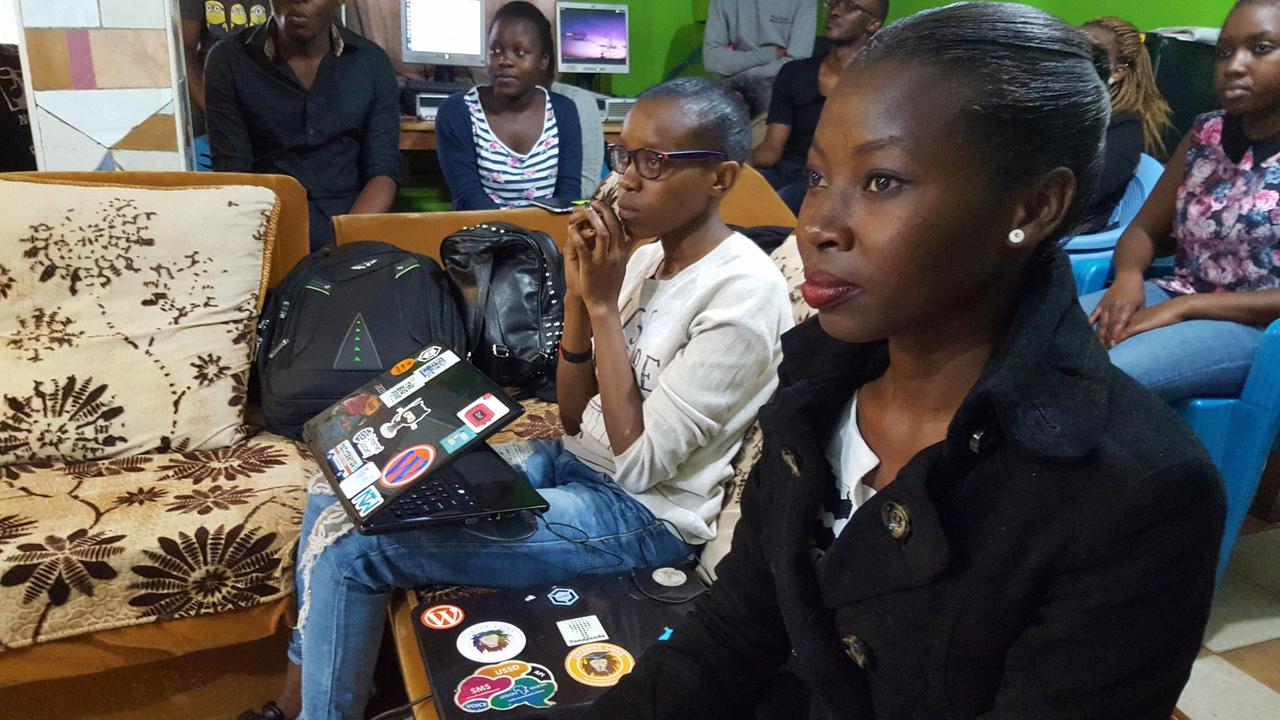 Lehrerin Moreen Moral vom kenianischen Tunapanda Institute. Sie sitzt auf einer Couch mit ihrem Laptop und schaut einer Präsentation zu. Lehrerin Moreen Moral vom kenianischen Tunapanda Institute. Sie sitzt auf einer Couch mit ihrem Laptop und schaut einer Präsentation zu.
