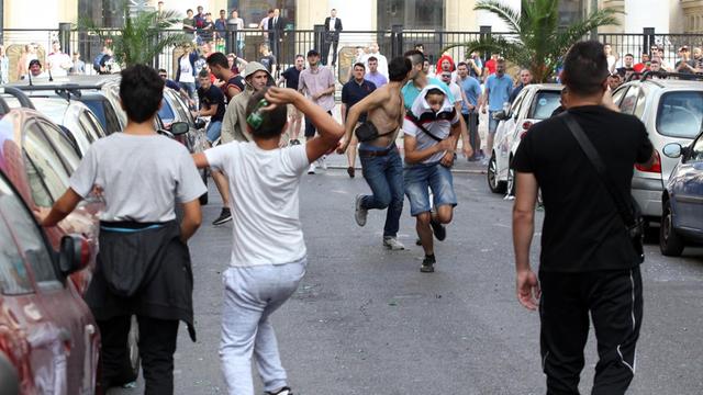 Straßenszene aus Marseille: Fans werfen Bierflaschen aufeinander, einige rennen weg