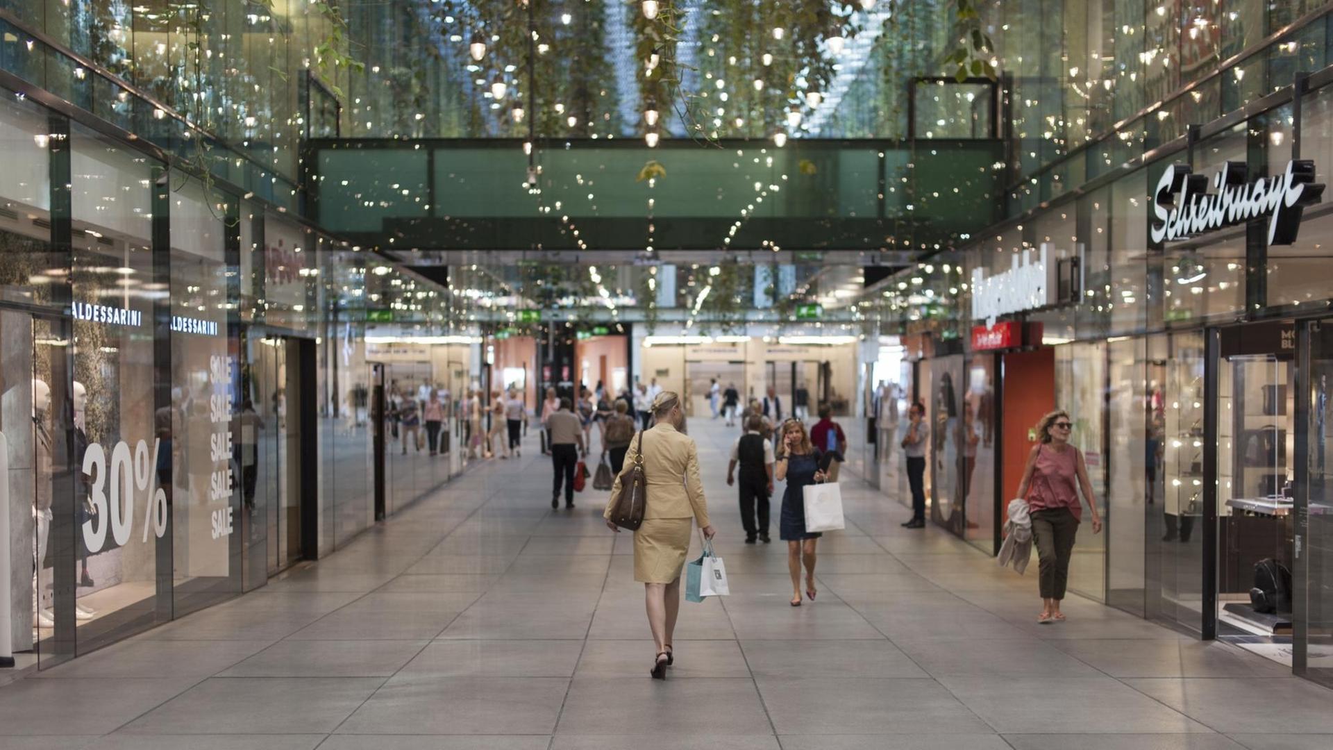 Frau geht durch ein Luxus-Shoppingcenter in München Frau geht durch ein Luxus-Shoppingcenter in München