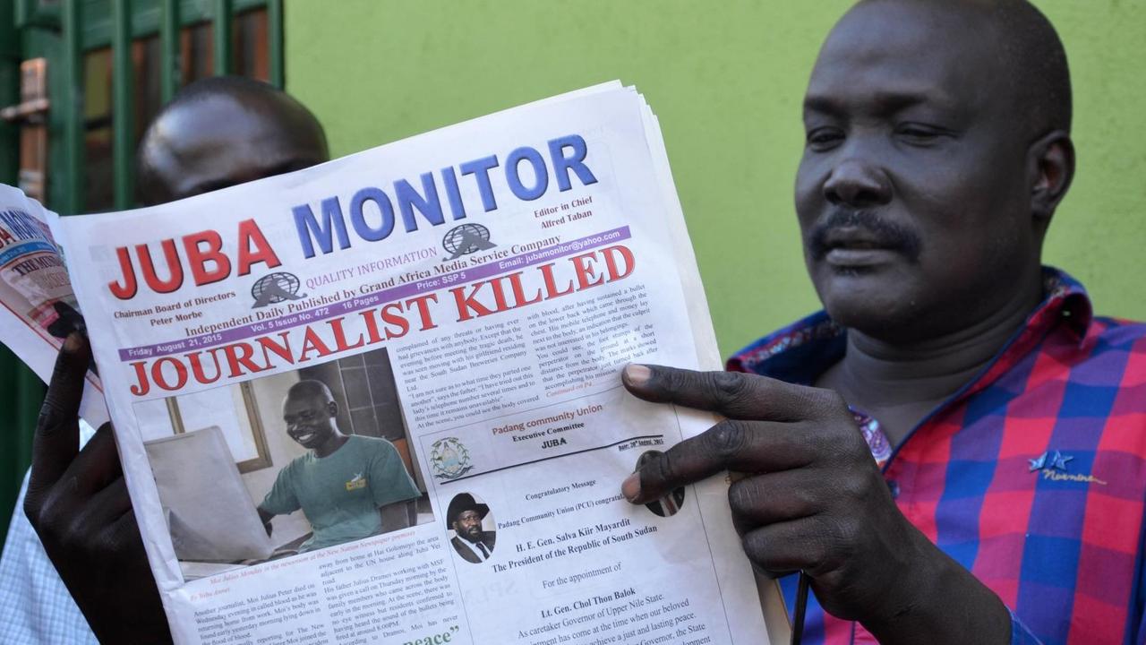 Ein schwarzer Mann sitzt vor einer grünen Wand und liest die Zeitung "Juba Monitor". Die Schlagzeile lautet "Journalist killed". Darunter ist ein Bild des ermordeten Julius Moi zu sehen. Ein schwarzer Mann sitzt vor einer grünen Wand und liest die Zeitung "Juba Monitor". Die Schlagzeile lautet "Journalist killed". Darunter ist ein Bild des ermordeten Julius Moi zu sehen.