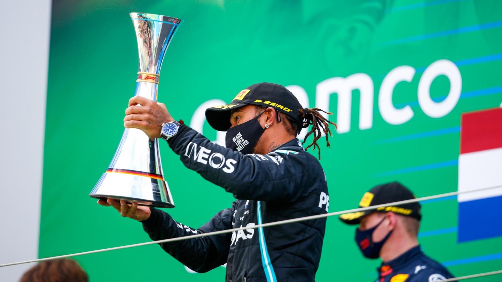 Formel-1-Pilot Lewis Hamilton hält den Siegerpokal hoch. Formel-1-Pilot Lewis Hamilton hält den Siegerpokal hoch.