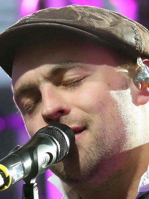 Max Mutzke, deutscher Sänger, Songwriter und Musiker, zu sehen bei einem Konzert - die Augen beim Gesang geschlossen.