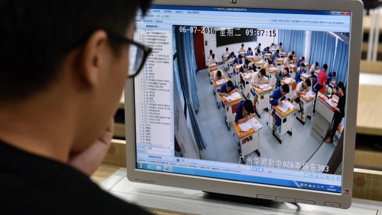 Ein Inspektor beobachtet die Schüler an einer chinesischen Schule in Guangzhou Ein Inspektor beobachtet die Schüler an einer chinesischen Schule in Guangzhou