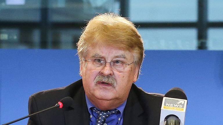 Elmar Brok sitzt an einem Tisch und spricht in ein Mikrofon Elmar Brok sitzt an einem Tisch und spricht in ein Mikrofon