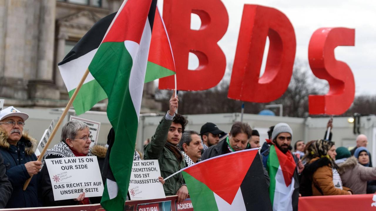 Anhänger der BDS-Kampagne tragen vor dem Reichstagsgebäude palästinensische Flaggen. Anhänger der BDS-Kampagne tragen vor dem Reichstagsgebäude palästinensische Flaggen.