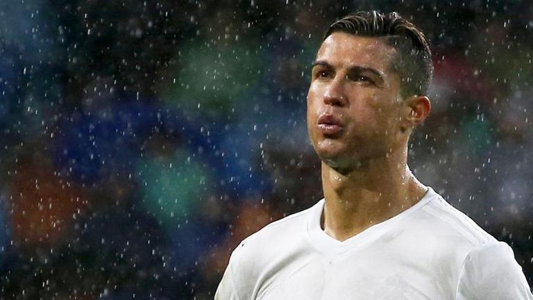 Cristiano Ronaldo von Real Madrid steht während des Spiels gegen Sporting Gijon am 26. November 2016 im Regen. Cristiano Ronaldo von Real Madrid steht während des Spiels gegen Sporting Gijon am 26. November 2016 im Regen.