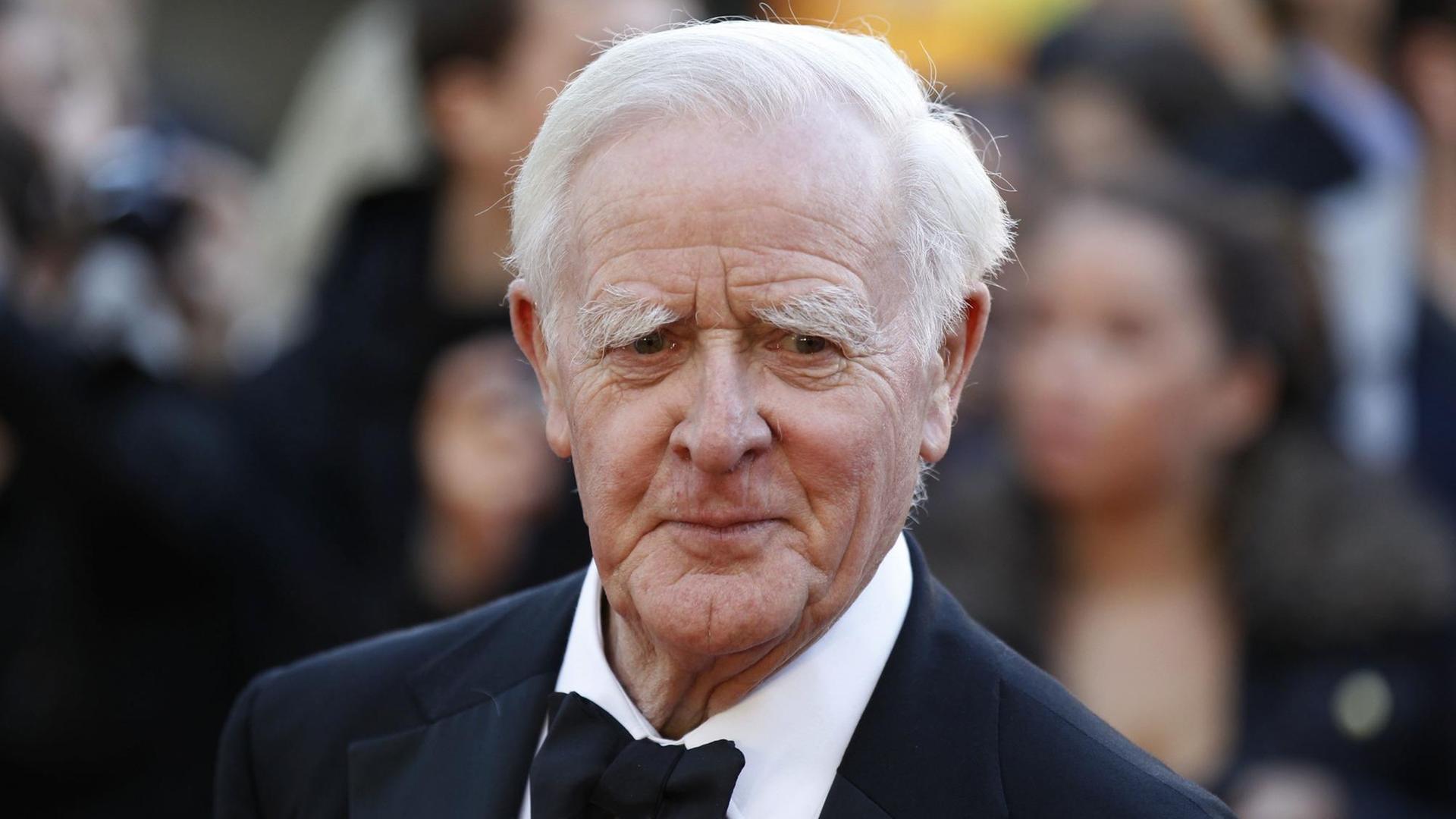 Der Schriftsteller John Le Carré trägt einen Anzug und eine Fliege. Der Schriftsteller John Le Carré trägt einen Anzug und eine Fliege.
