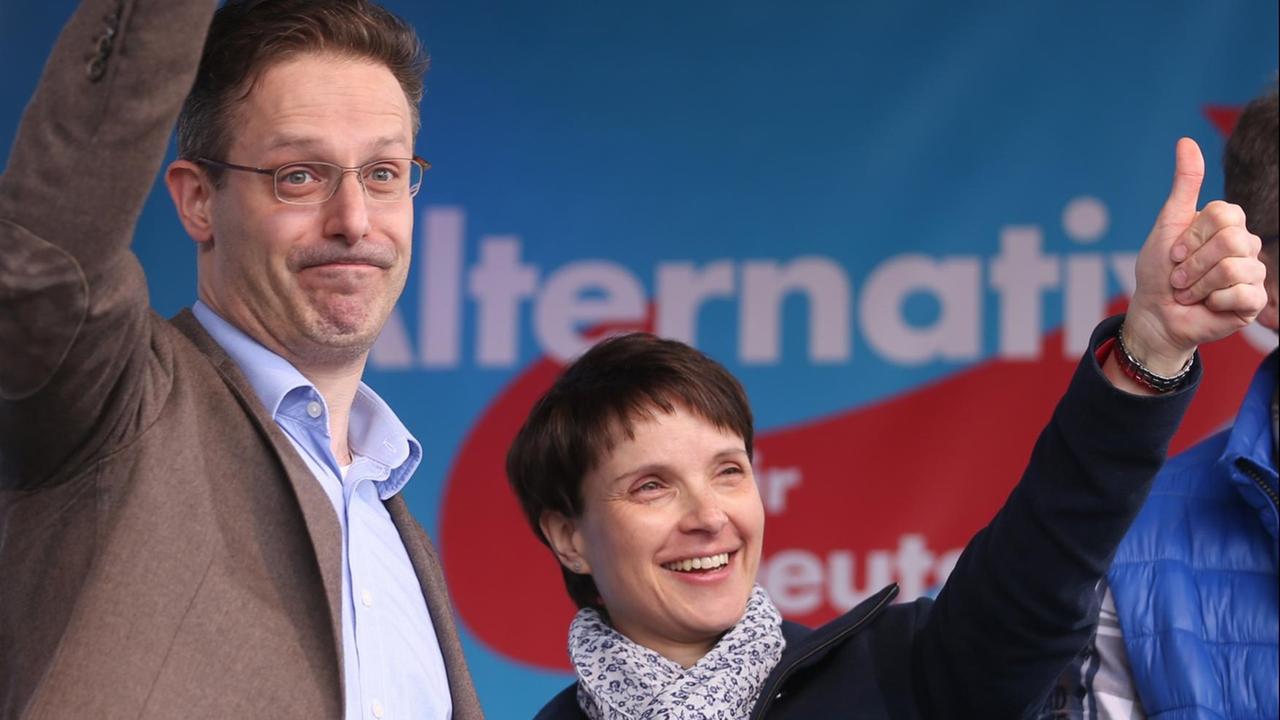 Pretzell und Petry stehen nebeneinander auf der Bühne und recken ihre Daumen in die Höhe. Pretzell und Petry stehen nebeneinander auf der Bühne und recken ihre Daumen in die Höhe.