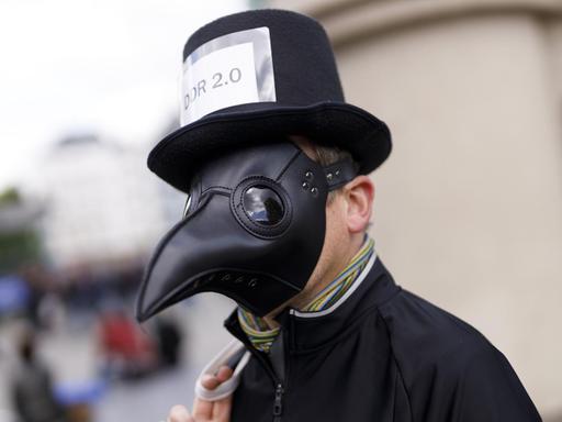 Schwarzgekleidet mit Pestmaske gegen die Maßnahmen in der Coronakrise: ein Mann am 1. Mai 2020 in der Kölner Innenstadt. 