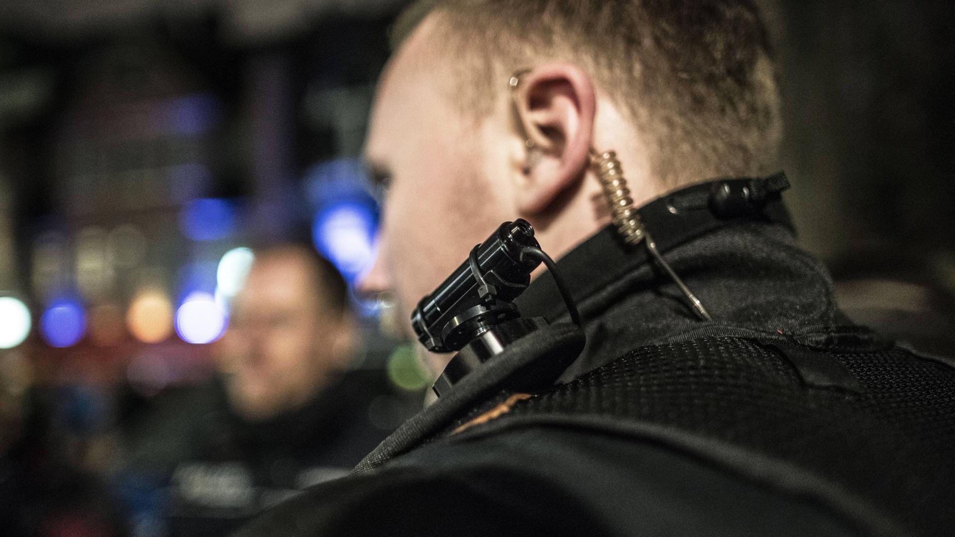 Ein uniformierter Polizist trägt bei einem Pressetermin zum Bodycam Einsatz im Kneipenviertel Alt-Sachsenhausen in Frankfurt eine Bodycam auf der Schulter.