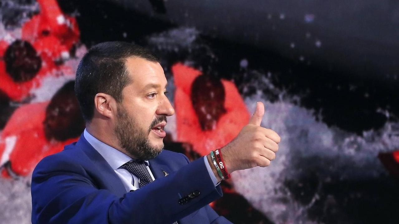 Italiens Innenminister Matteo Salvini in einer Fernsehdiskussion in Rom vor einem Bildschirm mit Schlauchboot und Flüchtingen, Juni 2018