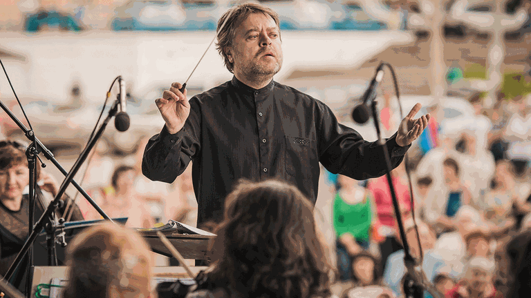 Der Dirigent Mark Kadin leitet das Krasnojarsker Symphonieorchester bei einem Open-Air-Konzert