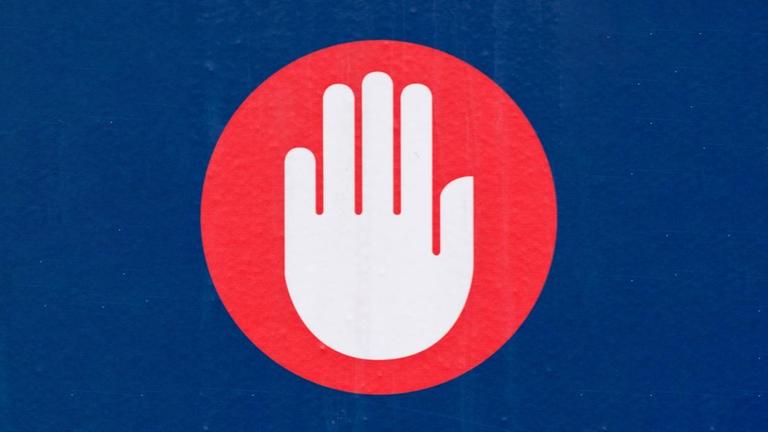 Ein Piktogram einer Hand vor einem roten Kreis, auf blauem Hintergrund. Ein Piktogram einer Hand vor einem roten Kreis, auf blauem Hintergrund.
