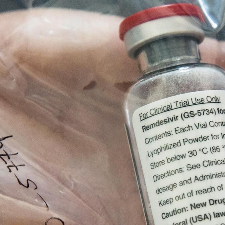 Eine Ampulle des Medikaments liegt verpackt in einem Plastikbeutel auf einer Hand.