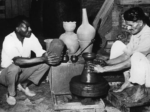 Copyright: imago/United Archives International An Asian pottery maker finishes off one of is last pots watched by his African helper. With most his clients gone he plans to join the the mass exodus of Kenyan Asians who are travelling to Britain to beat the British Government s proposed restrictions on immigration, the clampdown due to start the following week will only allow 1500 immigrants a year. Nairobi , Kenya 27 February 1968