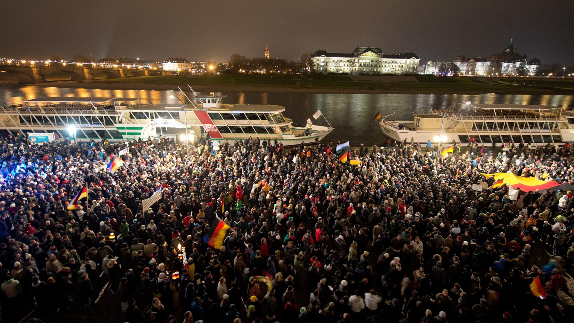 Teilnehmer einer Demonstration unter dem Motto "Patriotische Europäer gegen die Islamisierung des Abendlandes" (PEGIDA) warten am 01.12.2014 auf dem Terrassenufer in Dresden (Sachsen). Sie wollten zum Theaterplatz marschieren, wurden daran aber von Gegendemonstranten gehindert. Teilnehmer einer Demonstration unter dem Motto "Patriotische Europäer gegen die Islamisierung des Abendlandes" (PEGIDA) warten am 01.12.2014 auf dem Terrassenufer in Dresden (Sachsen). Sie wollten zum Theaterplatz marschieren, wurden daran aber von Gegendemonstranten gehindert.