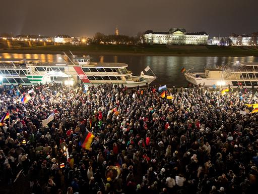 Teilnehmer einer Demonstration unter dem Motto "Patriotische Europäer gegen die Islamisierung des Abendlandes" (PEGIDA) warten am 01.12.2014 auf dem Terrassenufer in Dresden (Sachsen). Sie wollten zum Theaterplatz marschieren, wurden daran aber von Gegendemonstranten gehindert.