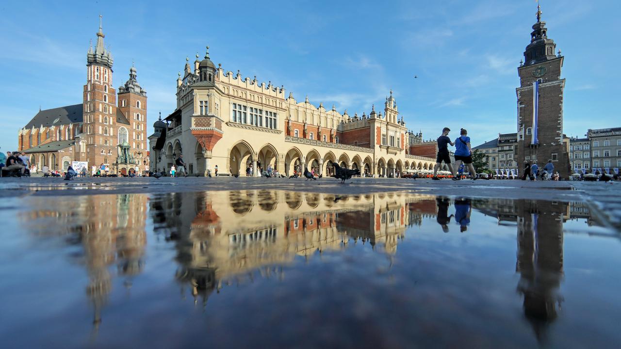 Der Marktplatz von Krakau in Polen mit der Marienkirche, den Tuchhallen und dem Rathausturm Der Marktplatz von Krakau in Polen mit der Marienkirche, den Tuchhallen und dem Rathausturm